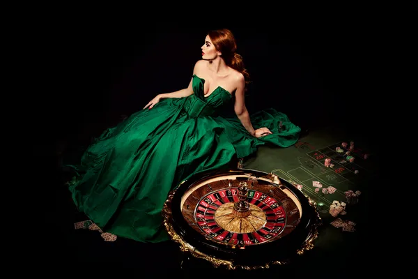 CD33 — A high-class gaming experience without limits A woman in a luxurious green gown next to an ornate roulette wheel, capturing the upscale casino mood of CD33.