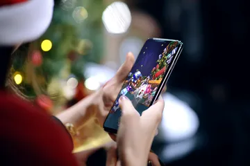 CD33 Mobile Casino — Play anytime, anywhere A player using their smartphone during a festive local event, representing CD33’s fully mobile-friendly casino.